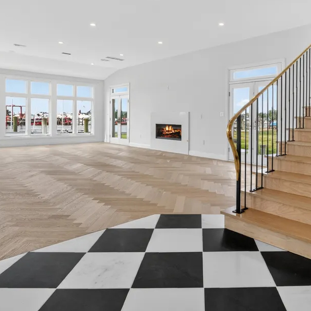 Prefinished White Oak Herringbone pattern installed with a direct glue on concrete slab and White Oak square nose staircase.